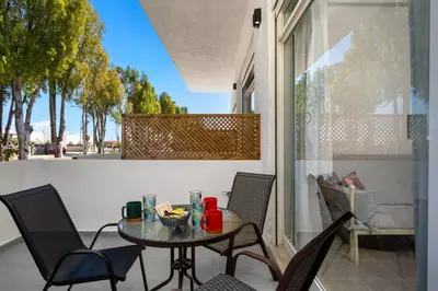 a patio with a table and chairs on a balcony at Sokrates Apartments in Kolimbia