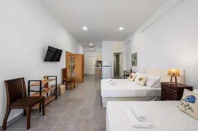 a hotel room with two beds and a living room at Sokrates Apartments in Kolimbia