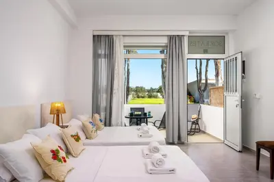 a room with two beds and a living room at Sokrates Apartments in Kolimbia