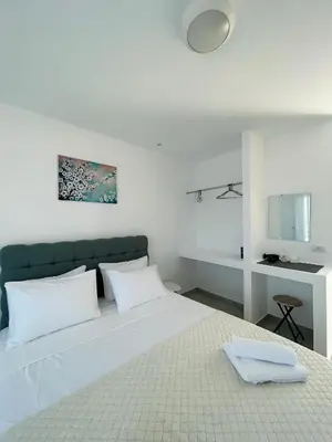 a bedroom with a large white bed with white pillows at Chrisanthi Apartments in Archangelos