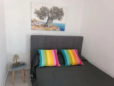 a bedroom with a bed with two colorful pillows at Maria Studios & Apartments in Kremasti