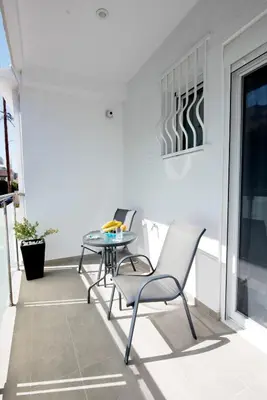 a patio with chairs and a table on a balcony at Maria Studios & Apartments in Kremasti