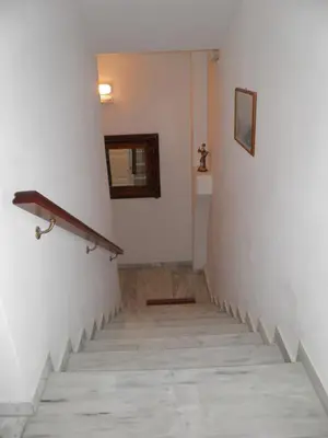 a hallway with a staircase with a mirror on the wall at Maria Studios & Apartments in Kremasti