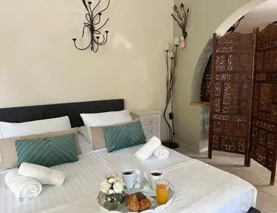 a bedroom with a bed with a tray of food on it at Theonia Villas in Pefki Rhodes