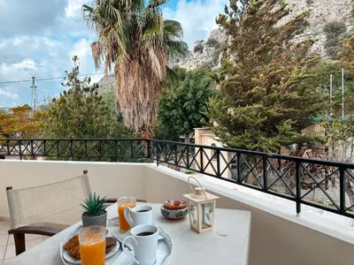 a breakfast table on a balcony with a view of the mountains at Theonia Villas in Pefki Rhodes