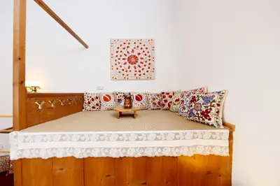 a bedroom with a wooden bed with pillows on it at Villa Annoula - Traditional Lindian House in Líndos