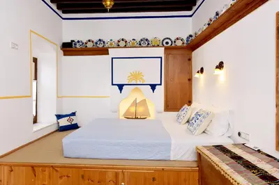 a bedroom with a bed and a tv on the wall at Villa Annoula - Traditional Lindian House in Líndos