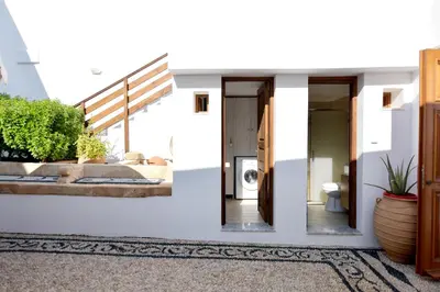 a white house with a staircase and a bathroom at Villa Annoula - Traditional Lindian House in Líndos