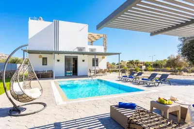 a villa with a swimming pool and a house at Villa Livis 1 in Kiotari