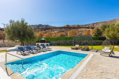 a swimming pool with lounge chairs at Villa Livis 1 in Kiotari