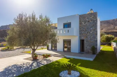 a white house with a tree in front of it at Villa Livis 1 in Kiotari