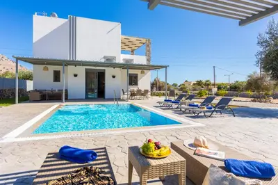 a villa with a swimming pool and a house at Villa Livis 1 in Kiotari