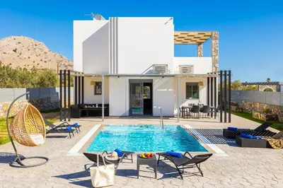 a villa with a swimming pool in front of a house at Villa Livis 2 in Kiotari