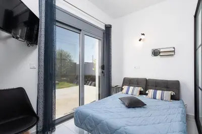 a bedroom with a bed and a sliding glass door at Villa Livis 2 in Kiotari