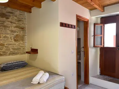 a room with a bed in the corner of a room at Symi Uptown Indigo in Symi