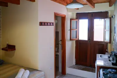 a room with a door and a kitchen with a sink at Symi Uptown Indigo in Symi