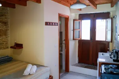 a room with a kitchen with a door and a sink at Symi Uptown Indigo in Symi