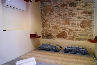 a room with two pillows on the floor next to a stone wall at Symi Uptown Indigo in Symi