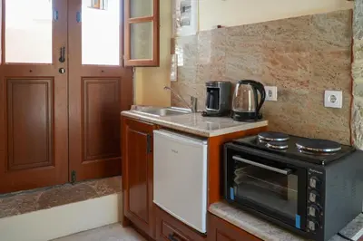 a small kitchen with a stove and a sink at Symi Uptown Indigo in Symi