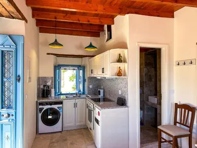 a kitchen with a washer and dryer in it at Symi Uptown Carmine in Symi