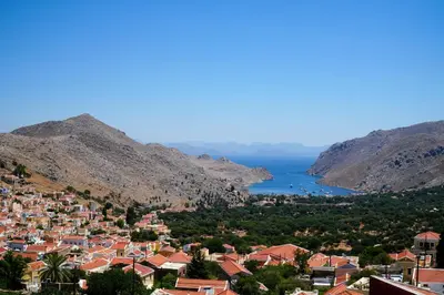 a view of a town on a hill with the ocean at Symi Uptown Carmine in Symi