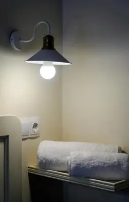 a room with a bed with a light on the wall at Symi Uptown Carmine in Symi