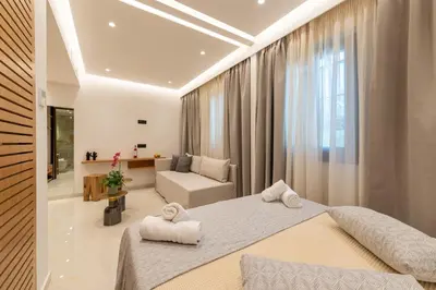 a bedroom with two beds and a living room at The Wine Hotel in Rhodes Town