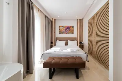 a bedroom with a large bed with a brown stool at The Wine Hotel in Rhodes Town