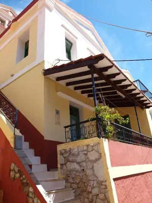 a house with stairs and a balcony at Marina Studios in Symi