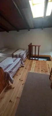 a room with two beds and a wooden floor at Marina Studios in Symi
