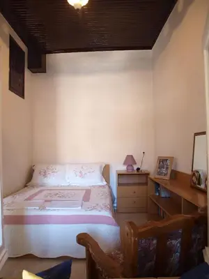 a small bedroom with a bed and a desk at Marina Studios in Symi
