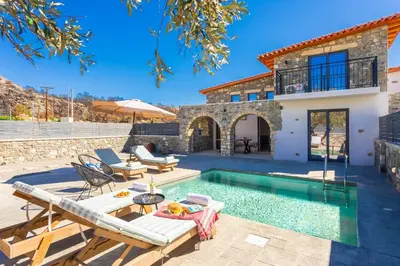 a villa with a swimming pool and a house at La Casa Di Pietre 1 in Kiotari