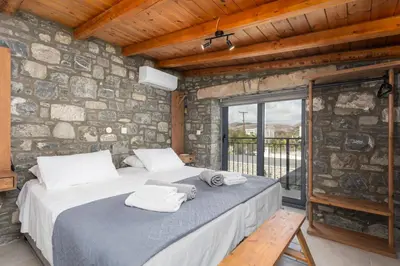a bedroom with a large bed in a stone wall at La Casa Di Pietre 1 in Kiotari