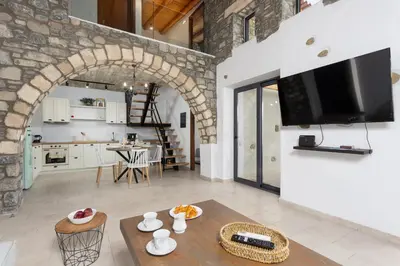 a kitchen and a living room with a table at La Casa Di Pietre 1 in Kiotari
