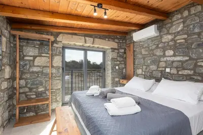a bedroom with a large bed in a stone wall at La Casa Di Pietre 1 in Kiotari