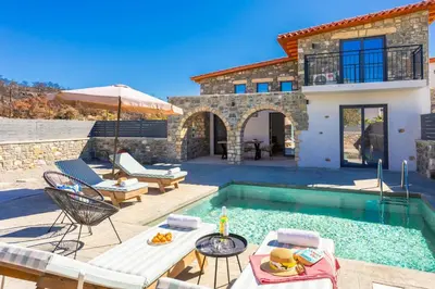 a villa with a swimming pool and a house at La Casa Di Pietre 1 in Kiotari