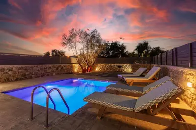a swimming pool with two lounge chairs and a table at La Casa Di Pietre 3 in Kiotari