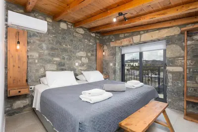 a bedroom with a bed in a stone wall at La Casa Di Pietre 3 in Kiotari