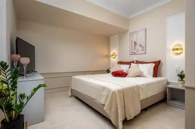 a bedroom with a bed with a red pillow on it at Alegrand Suites in Rhodes Town