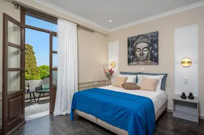 a bedroom with a bed with a painting on the wall at Alegrand Suites in Rhodes Town