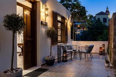 a patio with a table and chairs on a house at Alegrand Suites in Rhodes Town