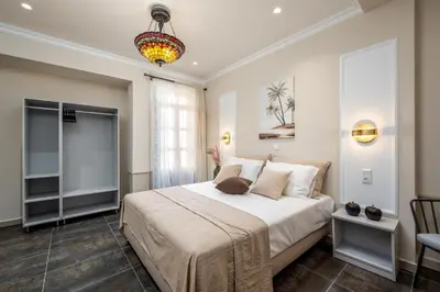 a bedroom with a large bed and a chandelier at Alegrand Suites in Rhodes Town