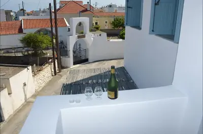 a bottle of wine sitting on a table with two glasses at Villa Polixeni Gennadi in Gennadi