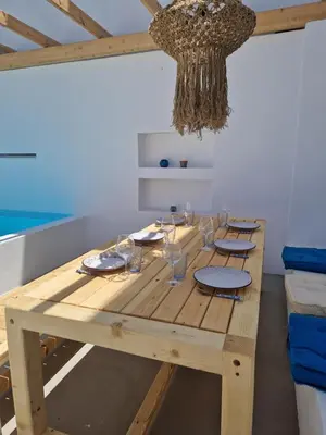 a wooden table in a room with a chandelier at Villa Polixeni Gennadi in Gennadi
