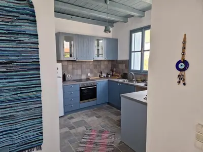 a kitchen with blue cabinets and a tile floor at Villa Polixeni Gennadi in Gennadi