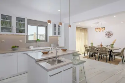 a kitchen with a sink and a dining room at Villa Elios Mare in Asklipiḯon