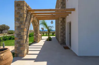 an arched walkway leading to a building with an archway at Villa Elios Mare in Asklipiḯon