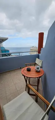 a table and chairs on a balcony with a view of the ocean at North Bay Apartments in Rhodes Town