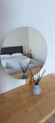 a bedroom with a bed with a round mirror at North Bay Apartments in Rhodes Town