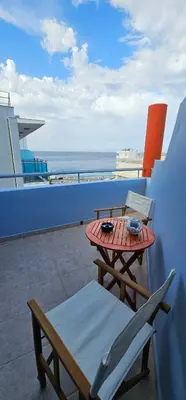 a table and chairs on a balcony with the ocean at North Bay Apartments in Rhodes Town
